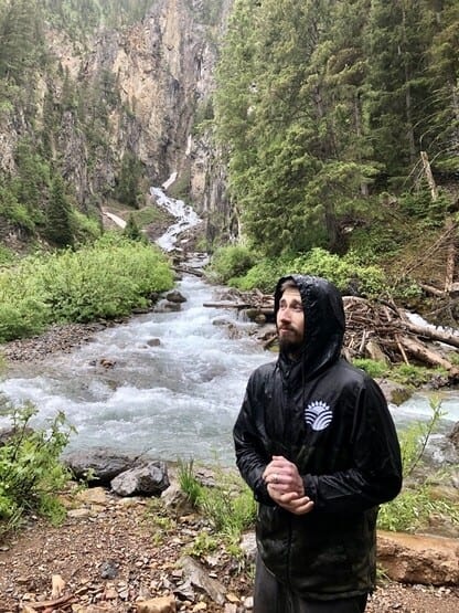 Me standing next to a waterfall near Idaho that leads into a rushing river.