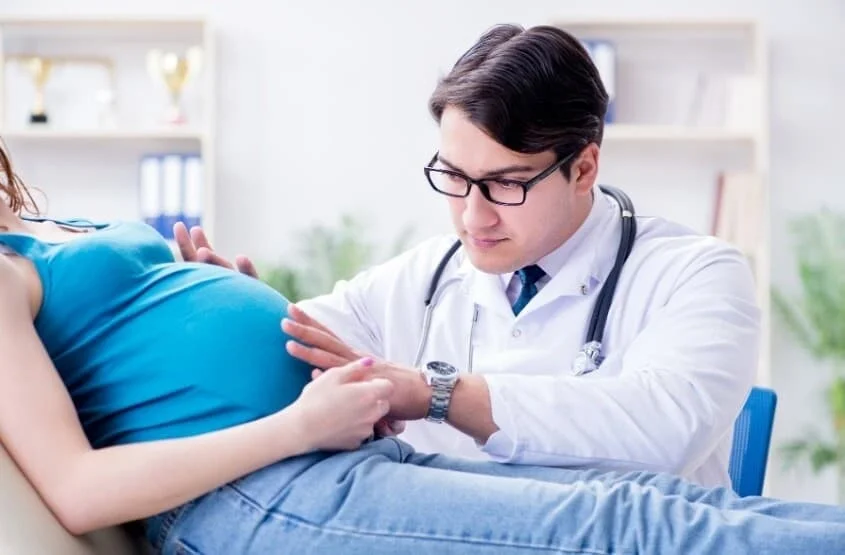 a pregnant traveler during a check up with her doctor