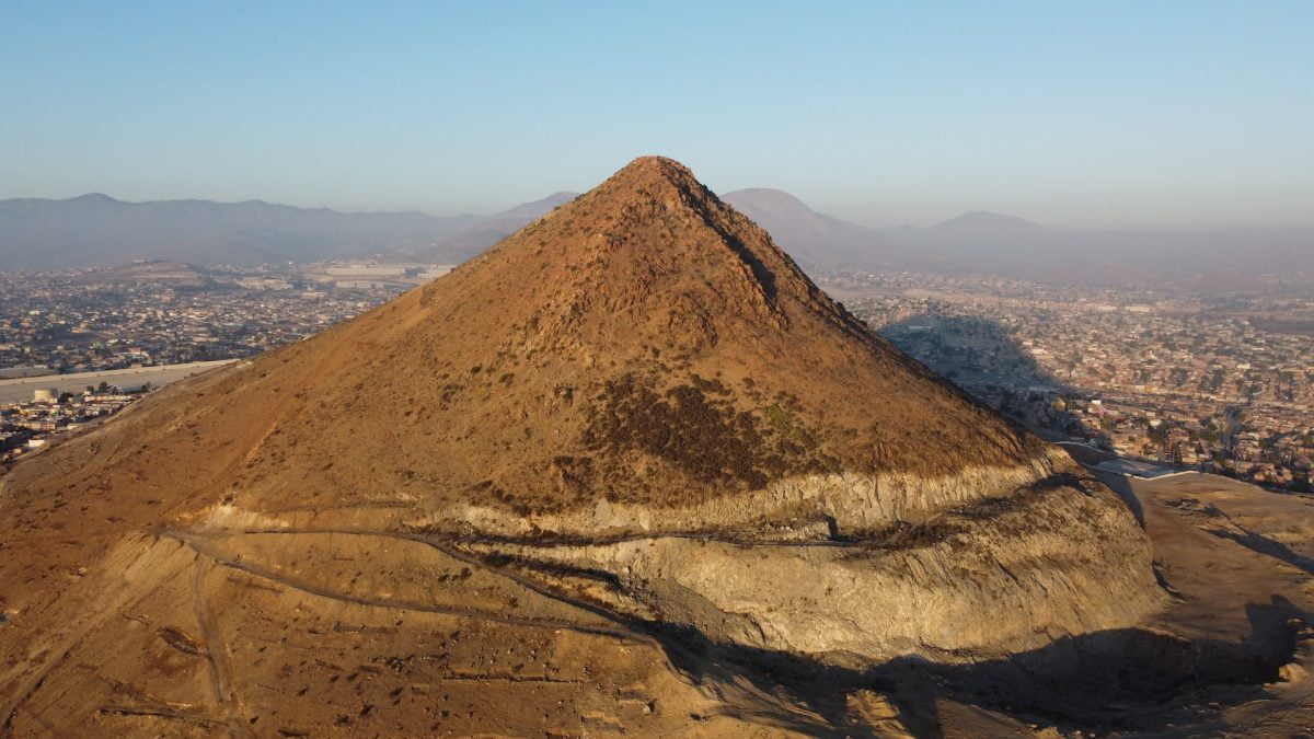 an aerial view of a mountain in Tijuana with a city in the background